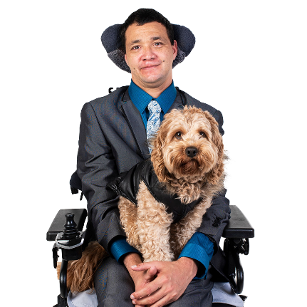 A person in a wheelchair with a support dog sitting on their lap.