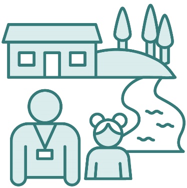 A person wearing a lanyard supporting a child. There is a mountain, trees, a river and a house behind them.