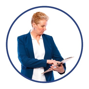 A person in a business suit writing on a document.