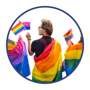 A person holding a small LGBTIQA+ flag in their hand. They also have a LGBTIQA+ flag around their shoulders.