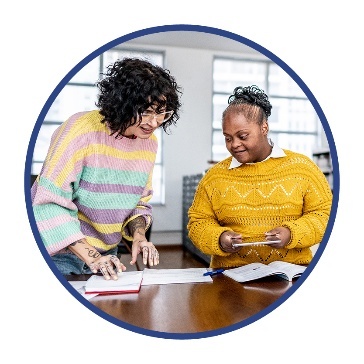 2 people working and looking at documents on a table.